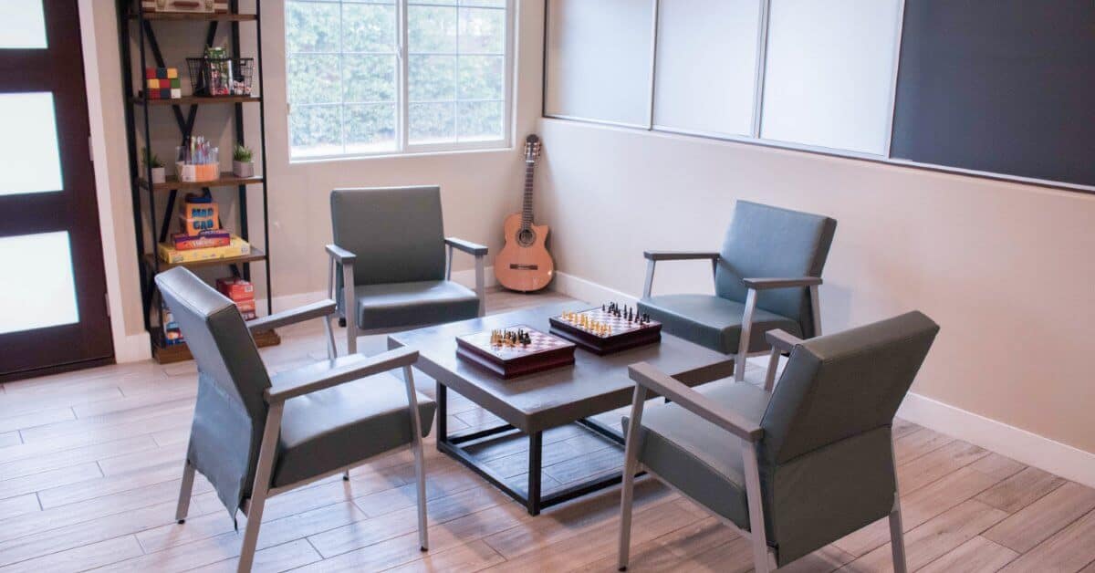Experience Recovery | Room with chairs, chess boards and a guitar
