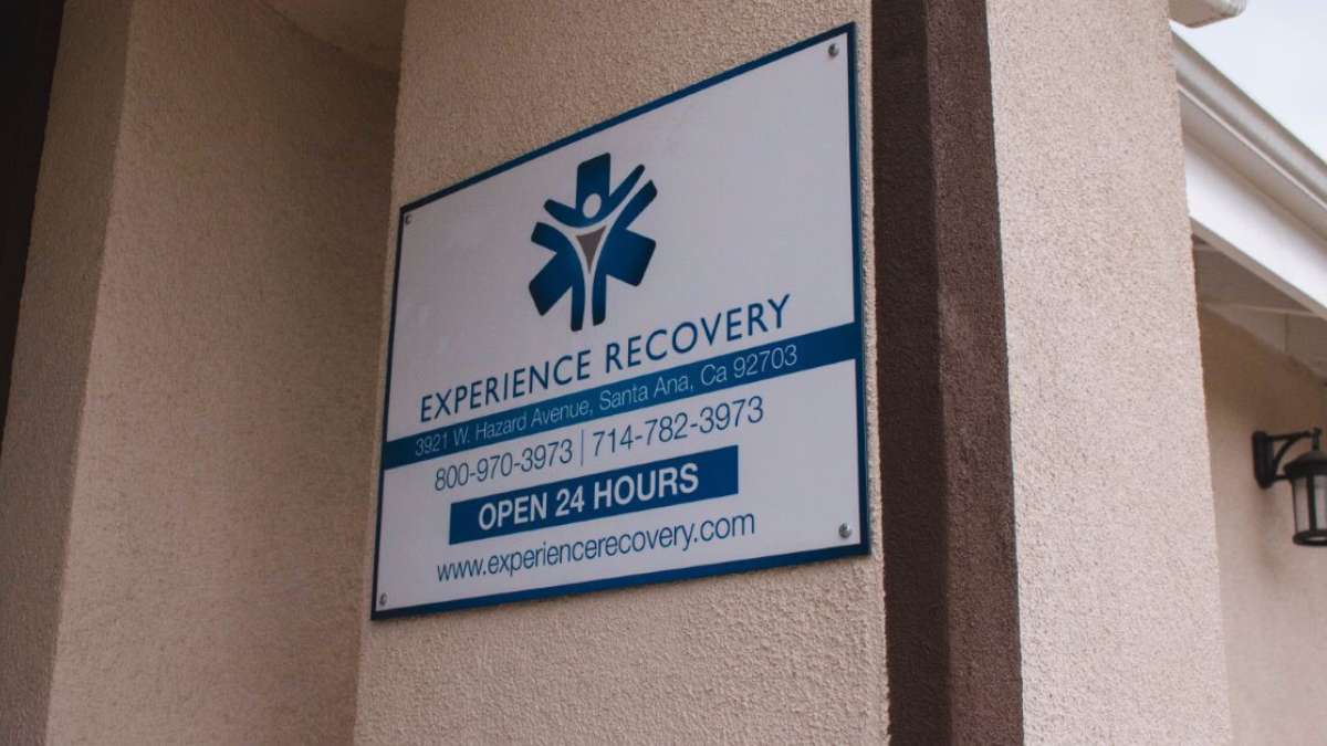 Information board at the entrance of the Experience Recovery rehab center, including website, address, phone numbers, and opening hours, so that people can contact us to start cognitive behavioral therapy in Orange County. 