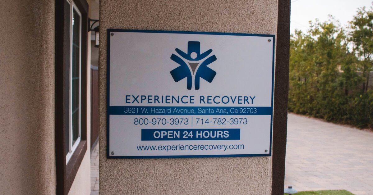 Information board at the entrance of the Experience Recovery facility containing address, phone number and website, where individuals can contact our center to learn more about outpatient programs.